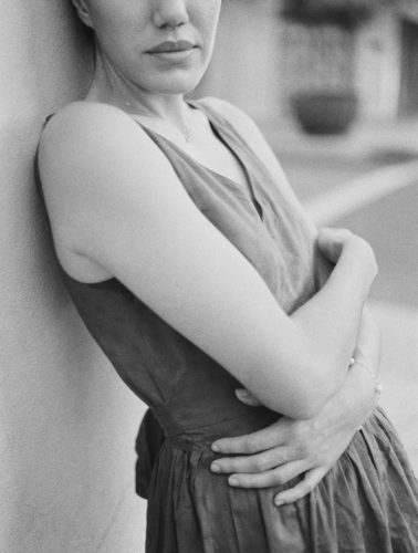 woman leaning against wall with arms crossed