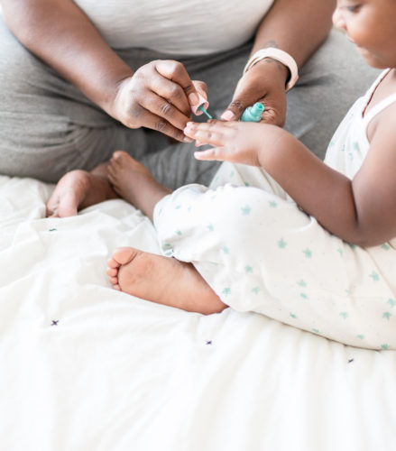 Woman painting daughter's fingernails