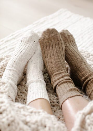 two pairs of feet in cozy socks