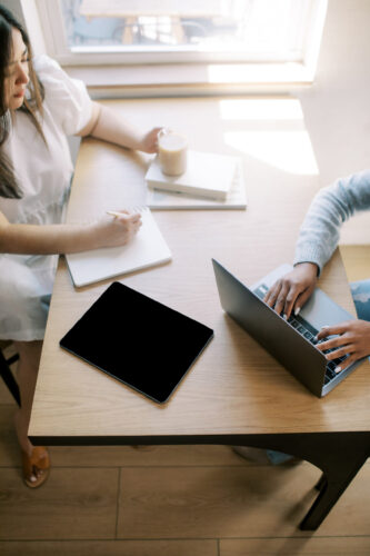 Overhead view of two women working on their computers