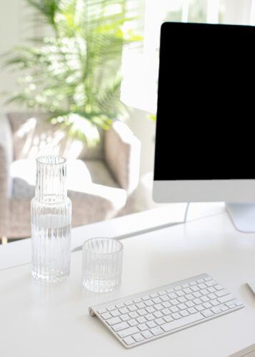 Computer and water glasses on desk